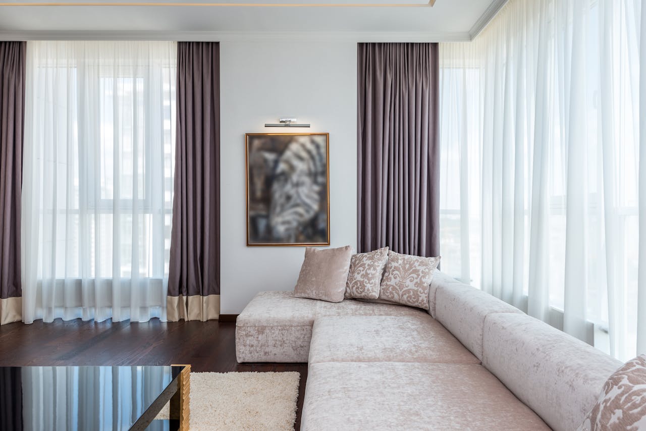 Bright and spacious modern living room featuring a sectional couch, large windows, and chic decor.